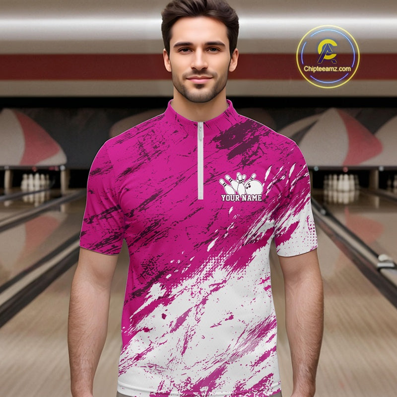 Man wearing a pink and white bowling shirt with a customizable logo in a bowling alley.