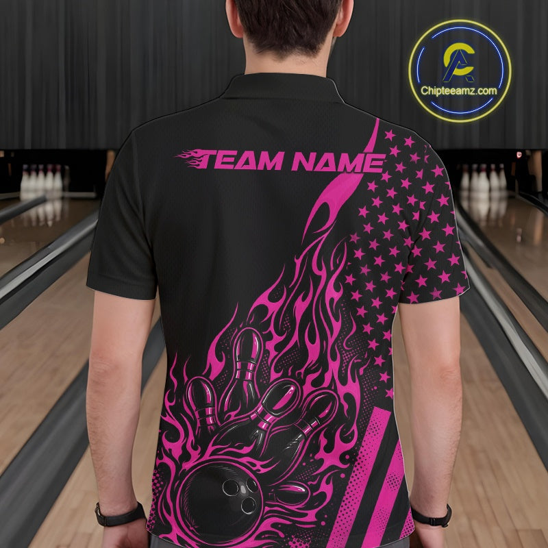 Back view of a male model in a bowling venue wearing a black polo shirt featuring a pink flaming bowling ball hitting the pins.