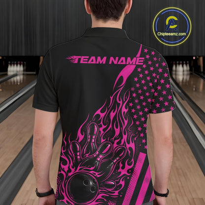 Back view of a male model in a bowling venue wearing a black polo shirt featuring a pink flaming bowling ball hitting the pins.