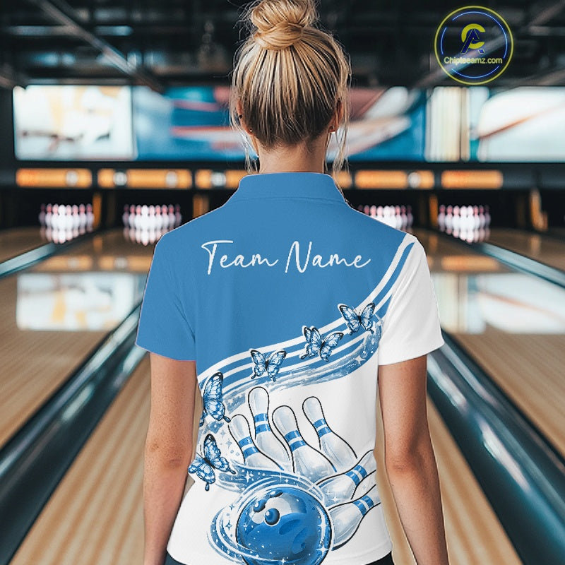 Female model wearing a white and blue bowling quarter zip with butterfly graphics and bowling artwork, back view inside a bowling alley