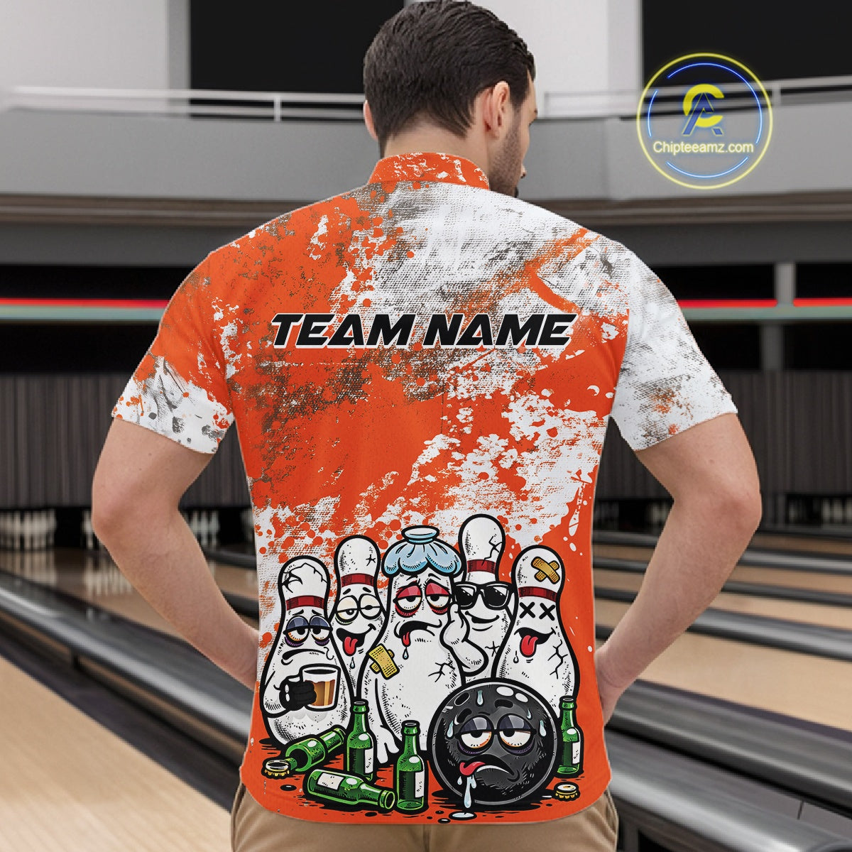 Male model at a bowling lane wearing orange and white quarter zip shirt, front view showcasing splatter background with bowling pins and bowling ball character design