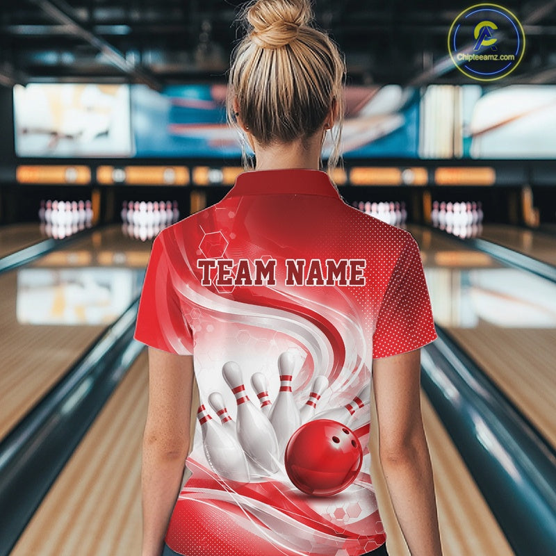 Female model standing in a bowling lane showing the back of a white and red bowling quarter-zip shirt with abstract wave lines and a glossy bowling ball striking pins graphic.