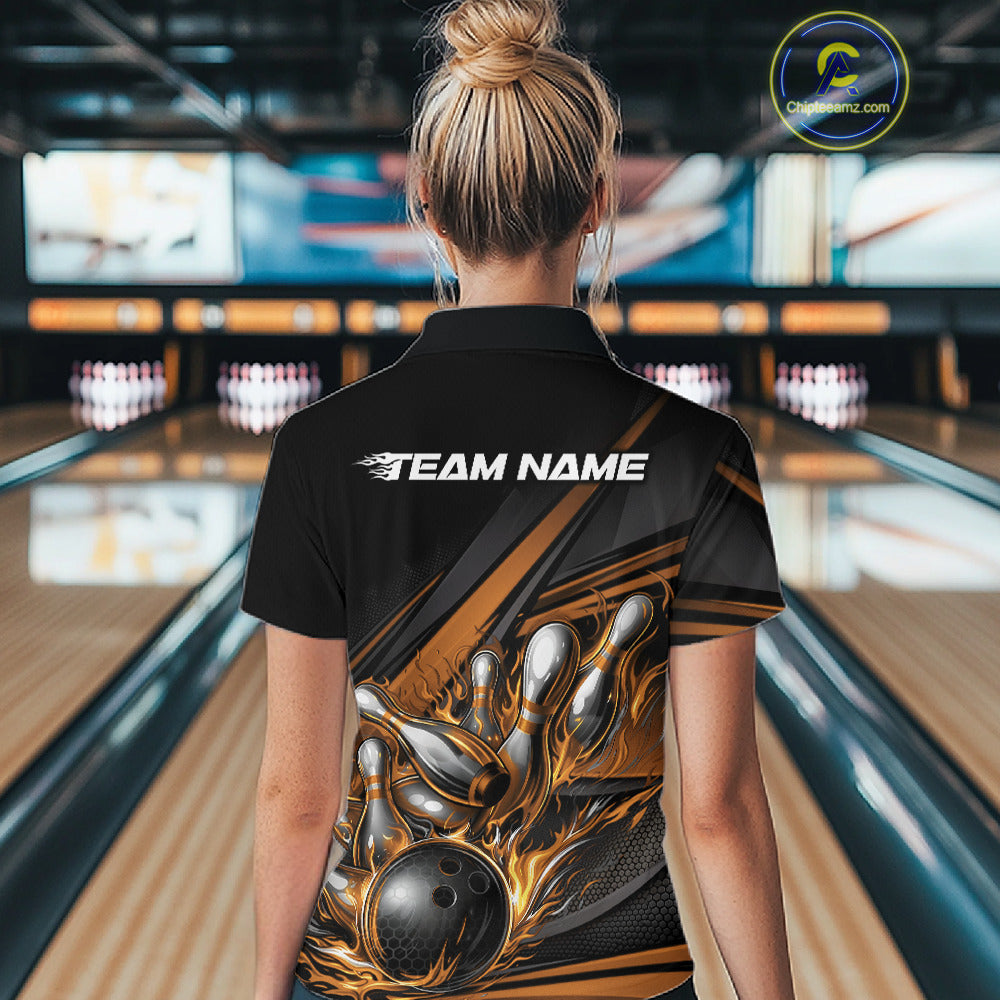 Back view of a female bowler wearing a black quarter-zip shirt, gold flame bowling strike artwork with geometric stripe accents.