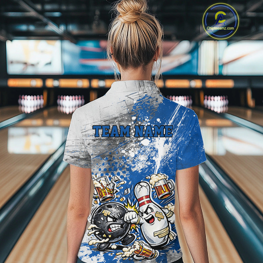 Back view of a female model in a bowling lane wearing a blue and white grunge splatter bowling quarter-zip shirt featuring humorous cartoon bowling ball and pin battling illustration.