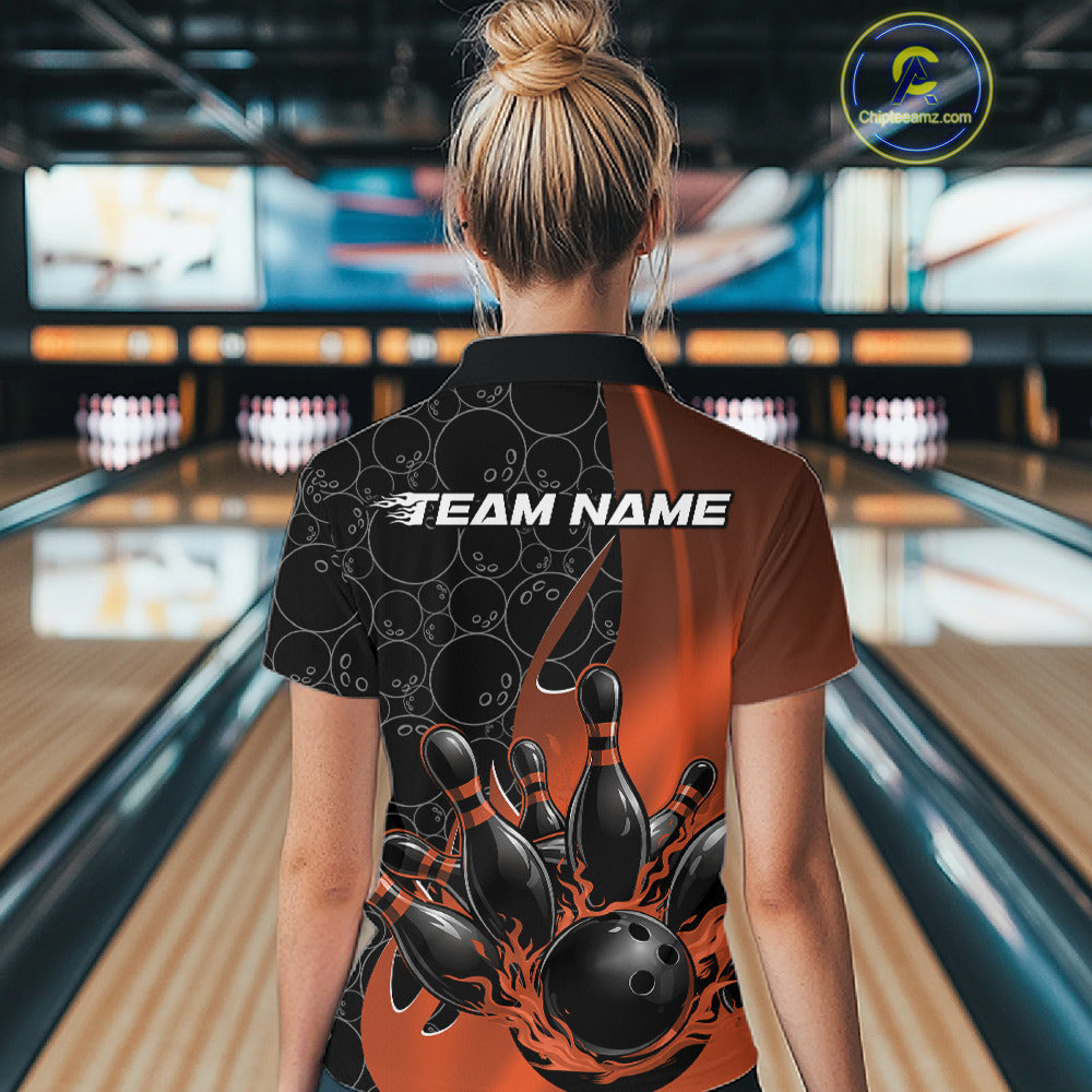 Female model at a bowling lane wearing black and orange quarter zip shirt, back view featuring flaming bowling ball hitting pins with gradient sports styling