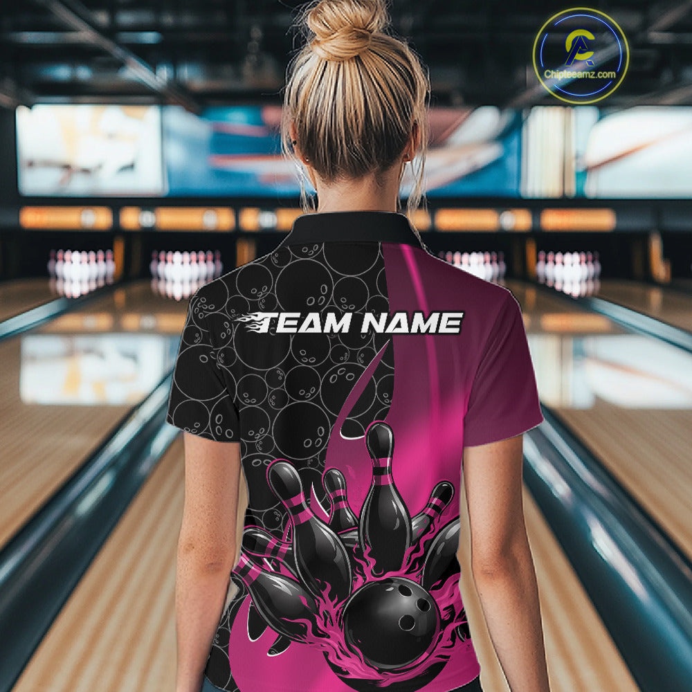 Female model at a bowling lane, back view of black and pink quarter zip shirt showcasing flaming bowling ball hitting pins with gradient accents