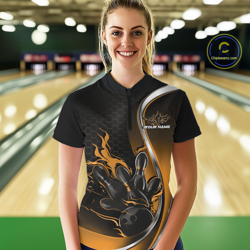 Female model front view at bowling lane wearing black and yellow quarter zip shirt with fiery bowling ball knocking down pins illustration