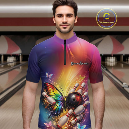 Male model wearing a bowling quarter-zip shirt at a bowling lane with a rainbow butterfly, bowling ball, and scattered pin artwork.