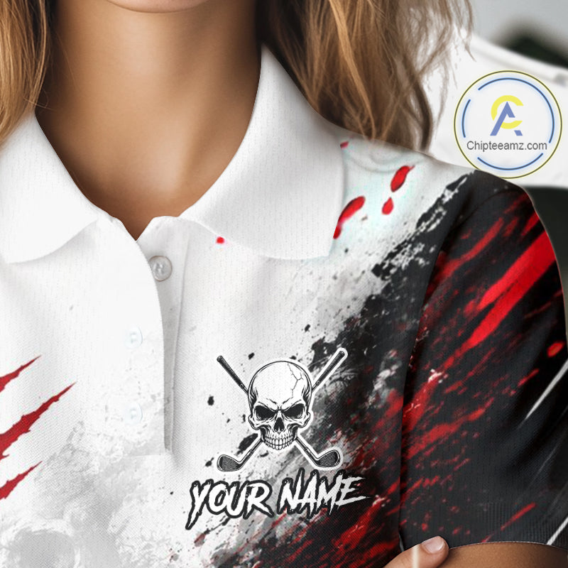 A close-up of a person wearing a white polo shirt with a custom pirate-themed graphic print. The design features a black and white skull and crossbones with golf clubs, red blood splatters, and a black section with red paint streaks on the right side.
