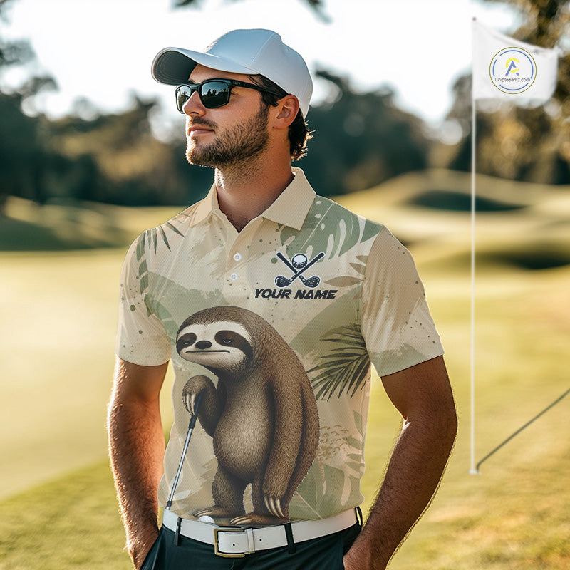 A man wearing a custom printed polo shirt with a sloth graphic and 'YOUR NAME' text, standing on a golf course. The shirt features a beige and green tropical pattern with a large sloth print on the front.