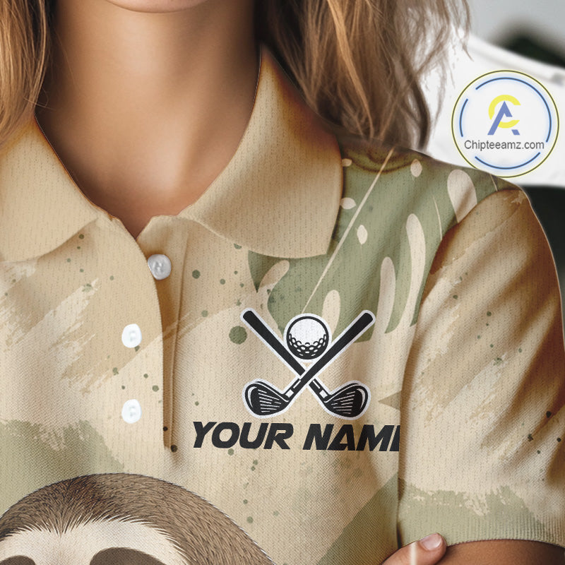A close-up of a person wearing a short-sleeve polo shirt with a beige and sage green camouflage pattern, featuring a black graphic of crossed golf clubs and a golf ball above the placeholder text 'YOUR NAME'.