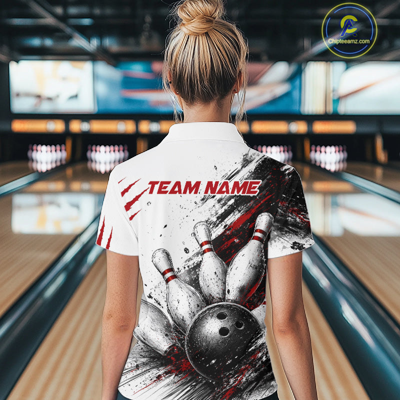 A woman viewed from behind wearing a white short-sleeve bowling-themed polo shirt with a large graphic of bowling pins, a bowling ball, and red 'TEAM NAME' text, standing in a bowling alley.