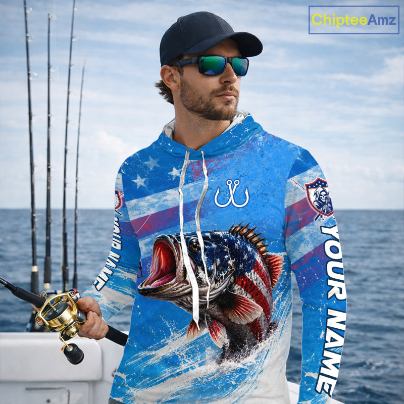 Man wearing a long sleeve hooded fishing shirt American flag design with custom name, standing on the boat.
