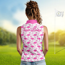 Load image into Gallery viewer, Woman wearing a white polo shirt with pink flamingo pattern and 'Team Name' text on the back, standing on a golf course.