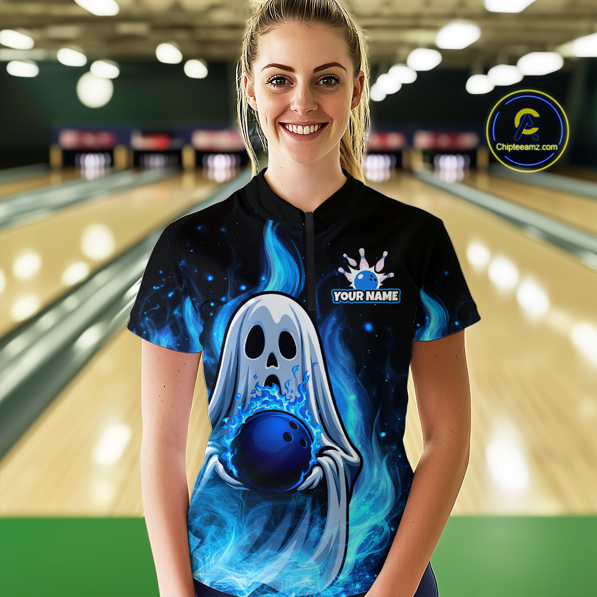 Person wearing a black bowling shirt with a blue ghost design in a bowling alley.